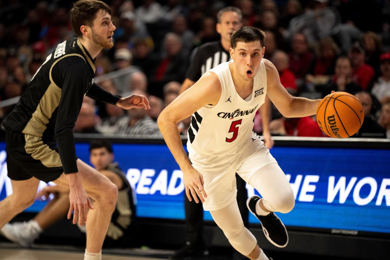 Cincinnati Bearcats guard CJ Fredrick (5) drives passed Bryant Bulldogs forward Connor Withers (7). Fredrick finshed with 14 points as UC beat Bryant 85-53.