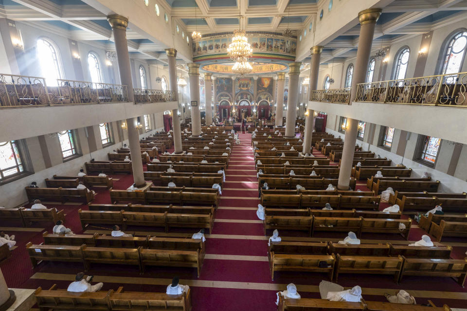 The congregation practises social distancing to curb the spread of the new coronavirus, as they sit a distance apart on pews and listen to a Sunday morning mass at the Bole Medhane Alem Ethiopian Orthodox Cathedral in Addis Ababa, Ethiopia Sunday, April 5, 2020. The new coronavirus causes mild or moderate symptoms for most people, but for some, especially older adults and people with existing health problems, it can cause more severe illness or death. (AP Photo/Mulugeta Ayene)