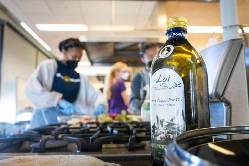 Students cut vegetables as chef and author Maria Loi helps teach them how to cook with olive oil Friday during a class hosted by the UC Davis Olive Center.