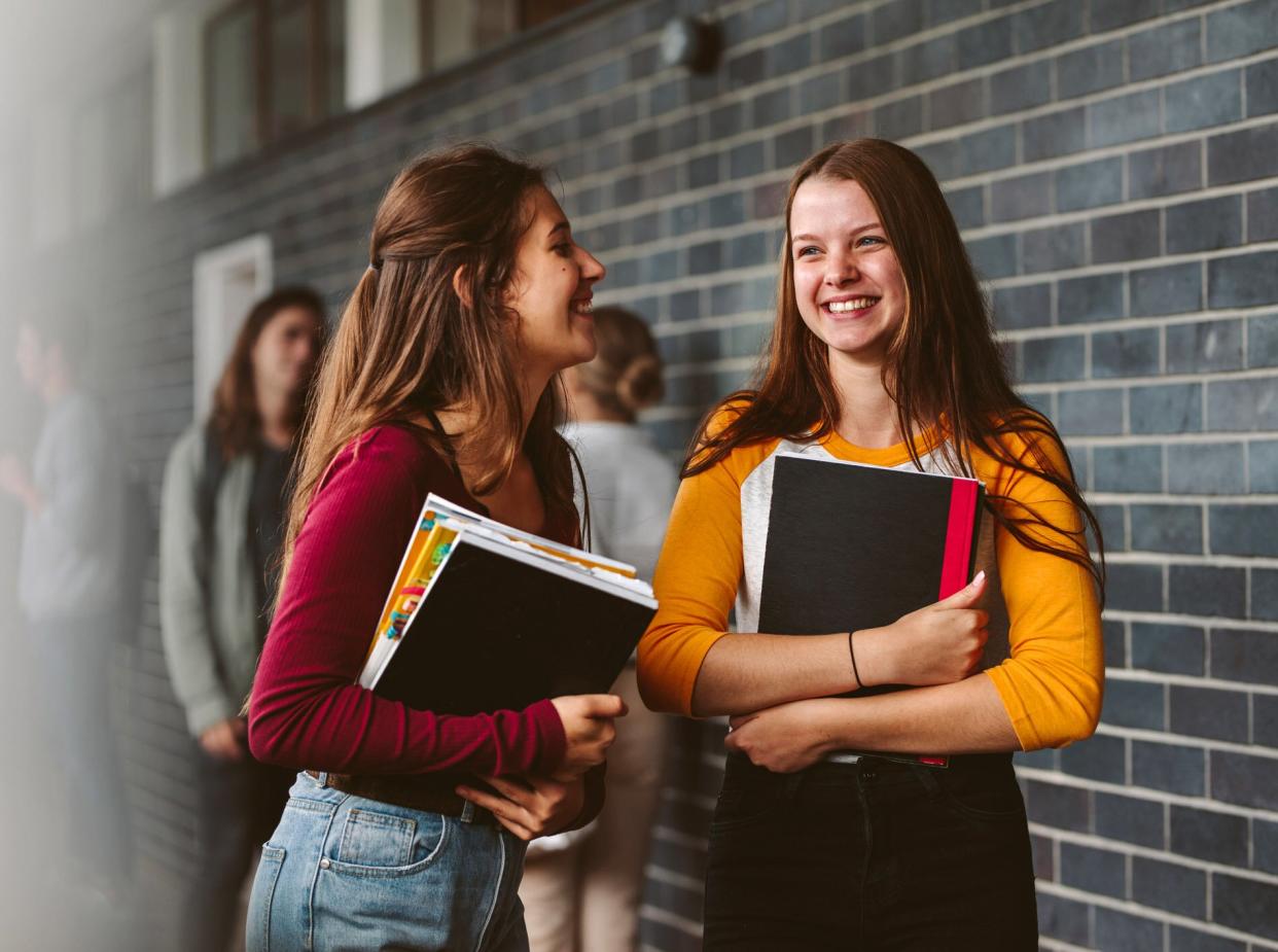 An image of two high school students in a hallway.