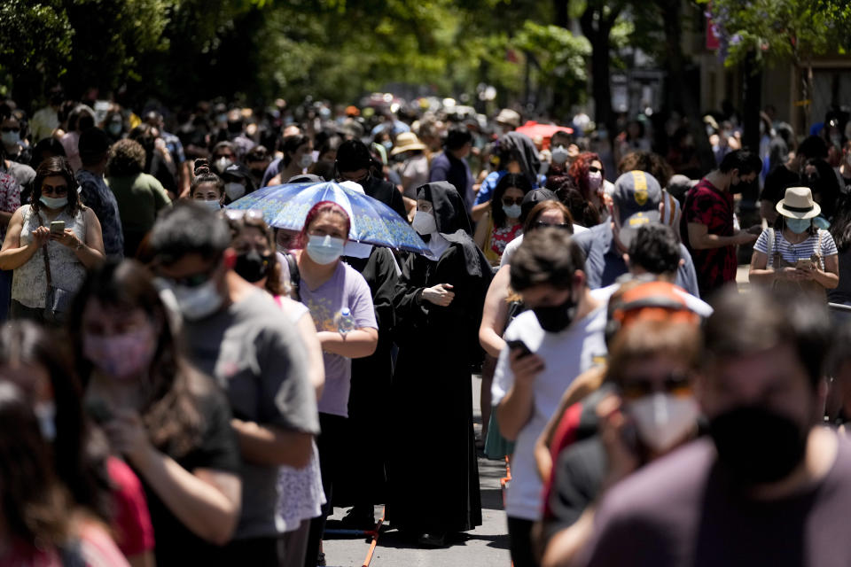 People line up to vote at a polling station during presidential elections in Santiago, Chile, Sunday, Nov. 21, 2021. (AP Photo/Esteban Felix)