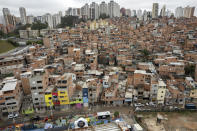 Workers paint the facades of residences in the Paraisopolis favela, as part of the community's centennial celebration, in Sao Paulo, Brazil, Thursday, Sept. 16, 2021. One of the largest favela's in Brazil, home to tens of thousands of residents in the country's largest and wealthiest city, Paraisopolis is grappling with crime and a pandemic that have challenged daily life for many who live there, but organizers say its people have built a vibrant community and are launching a 10-day celebration of its achievements. (AP Photo/Andre Penner)