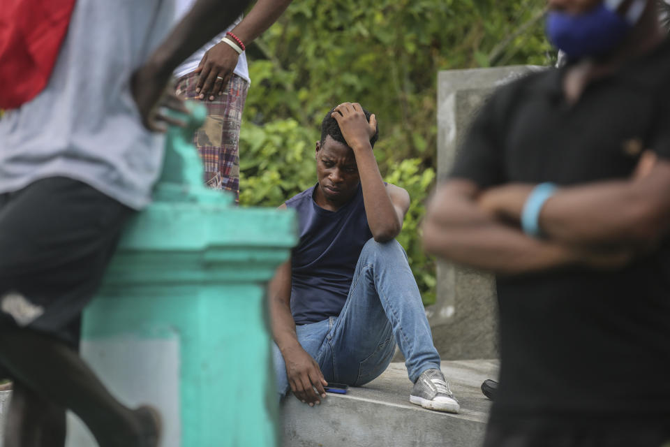 A relative attend sthe burial of Francois Elmay after his body was recovered from the rubble of a home destroyed by Saturday's 7.2 magnitude earthquake, in Tobek, Haiti, Wednesday, Aug. 18, 2021. (AP Photo/Joseph Odelyn)