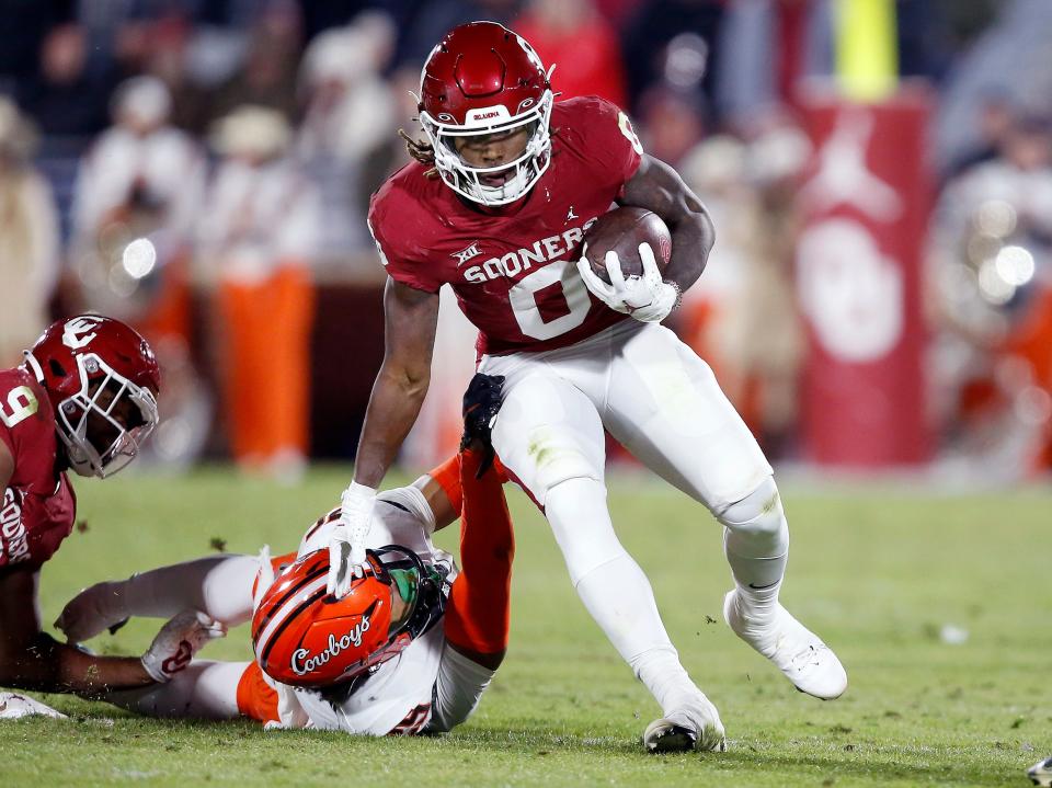 Oklahoma's Eric Gray (0) gets by Oklahoma State's Jason Taylor II (25) in the first half during the Bedlam college football game between the University of Oklahoma Sooners (OU) and the Oklahoma State University Cowboys (OSU) at Gaylord Family-Oklahoma Memorial Stadium, in Norman, Okla., Saturday, Nov., 19, 2022. 