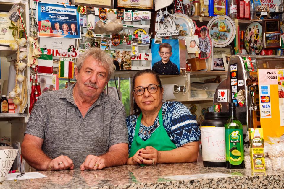 Owners of Tony's Italian Delicatessen, Vincent and Tina Abramo, pose for a photo at the counter in their deli in Phoenix on Sept. 22, 2022.