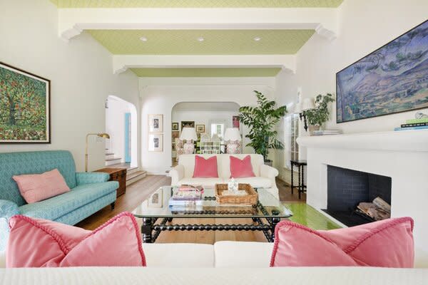 Colorful furniture in the main living room complements the light green ceiling and brickwork.