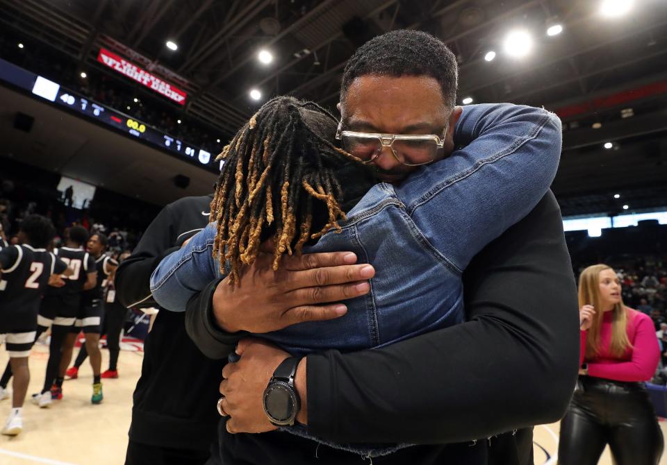 Buchtel boys basketball coach Rayshon Dent hugs his wife, Novella, after the Griffins defeated Lutheran West to win the OHSAA Division II state championship game March 19 at UD Arena in Dayton.