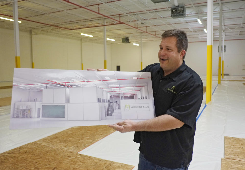 In this Dec. 5, 2013, photo, Pete Williams holds a drawing of the new grow facility that is being built at the Medicine Man dispensary and grow operation in northeast Denver. A gleaming white Apple store of weed is how Pete Williams sees his new Denver marijuana dispensary. Two floors of pot-growing rooms will have windows showing the shopping public how the mind-altering plant is grown. Shoppers will be able to peruse drying marijuana buds and see pot trimmers at work separating the valuable flowers from the less-prized stems and leaves.(AP Photo/Ed Andrieski)