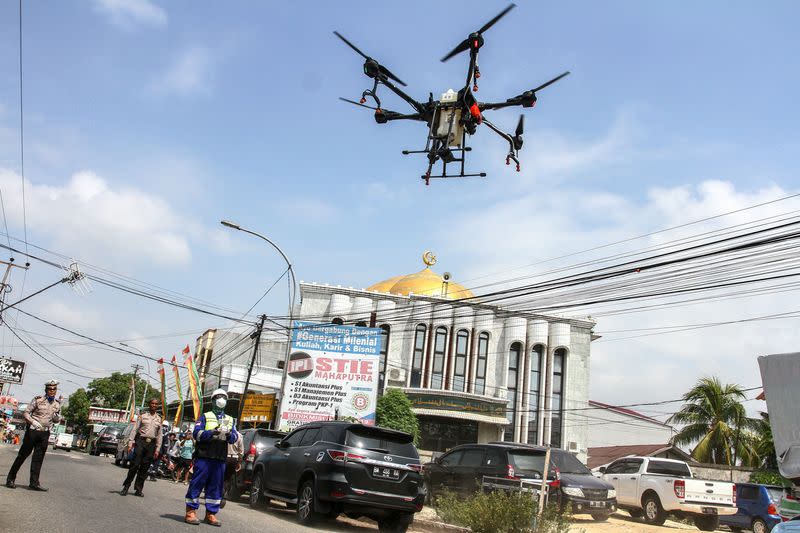 Police officer operates the drone to spray disinfectant to prevent the spread of coronavirus disease (COVID-19), in Pekanbaru