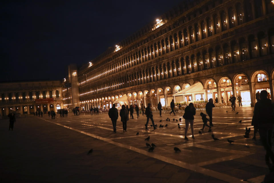 People walk along St. Mark's Square in Venice, Italy, Saturday, Feb. 29, 2020. A U.S. government advisory urging Americans to reconsider travel to Italy due to the spread of a new virus is the "final blow" to the nation's tourism industry, the head of Italy's hotel federation said Saturday. Venice, which was nearing recovery in the Carnival season following a tourist lull after record flooding in November, saw bookings drop immediately after regional officials canceled the final two days of celebrations this week, unprecedented in modern times. (AP Photo/Francisco Seco)