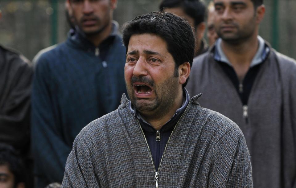 A Kashmiri villager wails near the bodies of Ghulam Nabi, a rural body head of a pro-Indian party and his son Firdous Ahmad during a joint funeral at Batgund village, some 40 kilometers (25 miles) south of Srinagar, India, Tuesday, April 22, 2013. Police say suspected rebels have killed three men in Indian Kashmir ahead of voting in general elections this week. More than a dozen rebel groups have been fighting for Kashmir's independence from India or merger with Pakistan since 1989. (AP Photo/Mukhtar Khan)