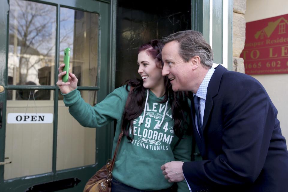 Britain's Prime Minister David Cameron poses for a selfie with a local woman as he campaigns in Alnwick