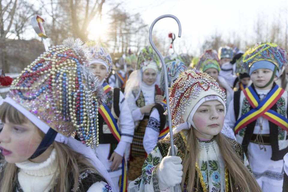 Participants, dressed in traditional costumes, celebrate the Malanka festival in the village of Krasnoilsk, Ukraine, Friday, Jan. 14, 2022. (AP Photo/Ethan Swope)