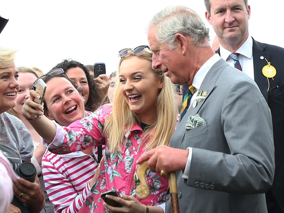 A woman takes a selfie with Prince Charles, Prince of Wales, in 2015.