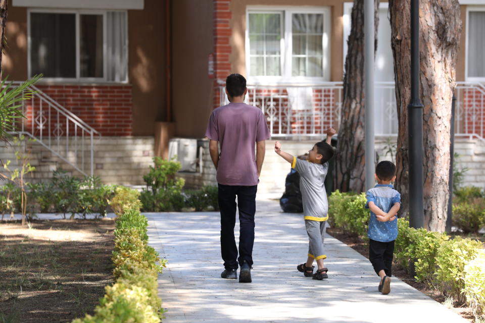 Afghans who were evacuated from Afghanistan walk at a tourist resort in Golem, west of the capital Tirana, Sunday, Aug. 29, 2021. Albania has sheltered 457 Afghan evacuees since Friday. (AP Photo/Franc Zhurda)