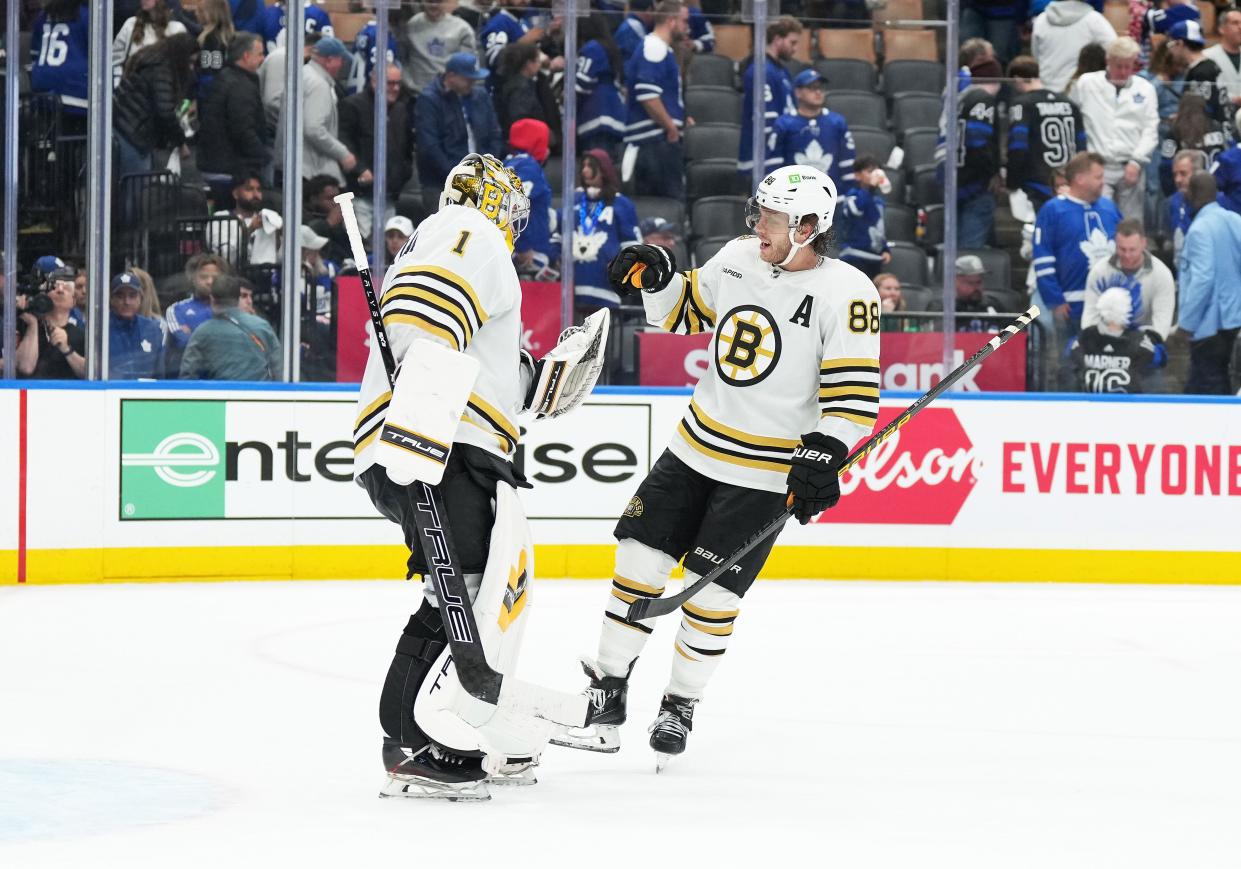 Boston Bruins goaltender Jeremy Swayman (1) and right wing David Pastrnak (88) celebrate a Game 4 win against the Toronto Maple Leafs.