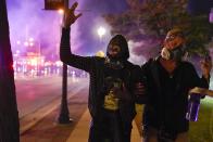 A protesters screams after police use tear gas Friday, Oct. 9, 2020, in Wauwatosa, Wis. On Wednesday, District Attorney John Chisholm refused to issue charges against Wauwatosa Police Officer Joseph Mensah for the Feb. 2 fatal shooting of 17-year-old Alvin Cole at Mayfair Mall. (AP Photo/Morry Gash)