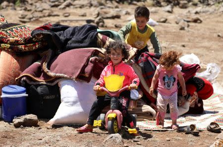 Internally displaced boy from Deraa province sits on a bicycle near the Israeli-occupied Golan Heights, in Quneitra, Syria June 21, 2018. REUTERS/Alaa al-Faqir