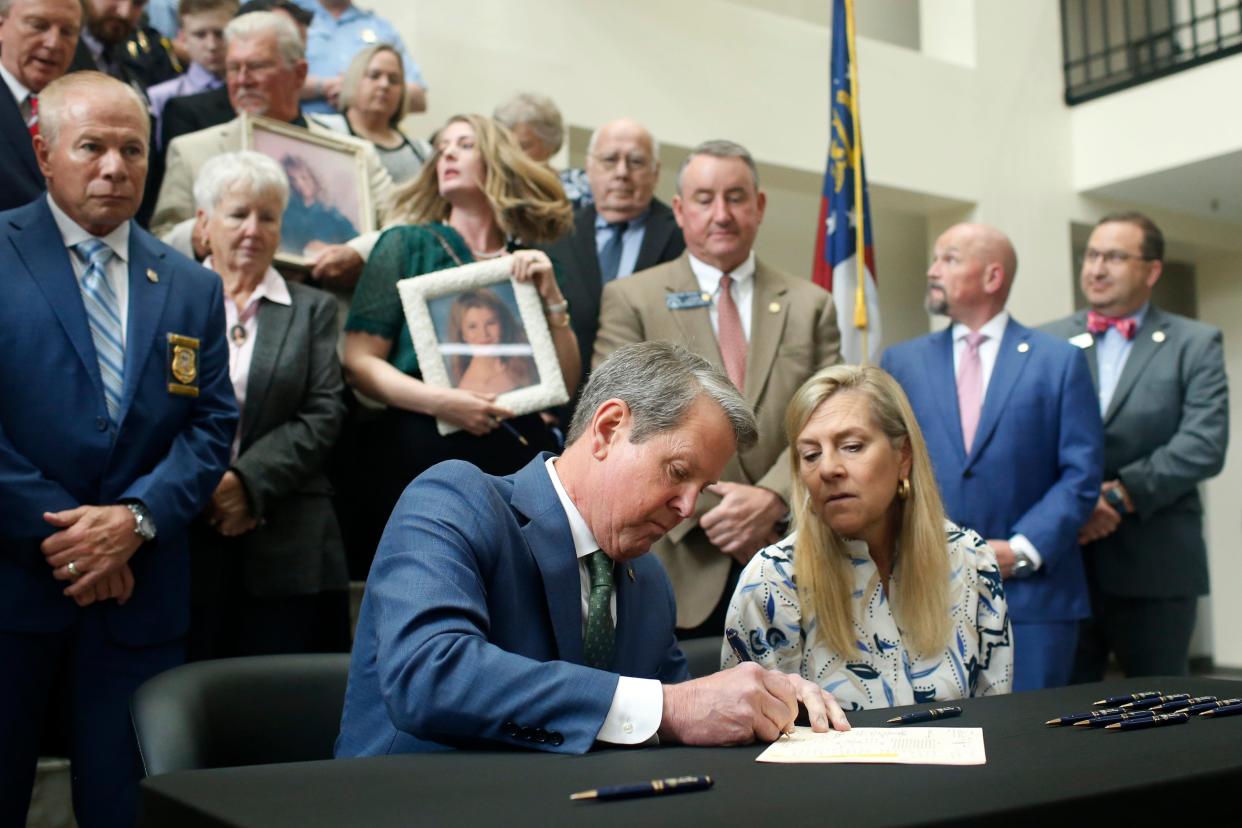 Georgia Gov. Brian Kemp signs HB 88, the Coleman-Baker Act, at the Athens-Clarke County Courthouse in downtown Athens, Ga., on Friday, April 28, 2023. The bill establishes a unit in the GBI to review cold cases.