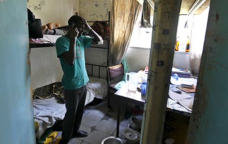 Harun Njoroge, a student at the University of Nairobi speaks on his mobile phone inside his room after receiving treatment after he jumped from the window at the Kimberly hostels at the Kikuyu campus near the capital Nairobi, April 12, 2015. REUTERS/Thomas Mukoya