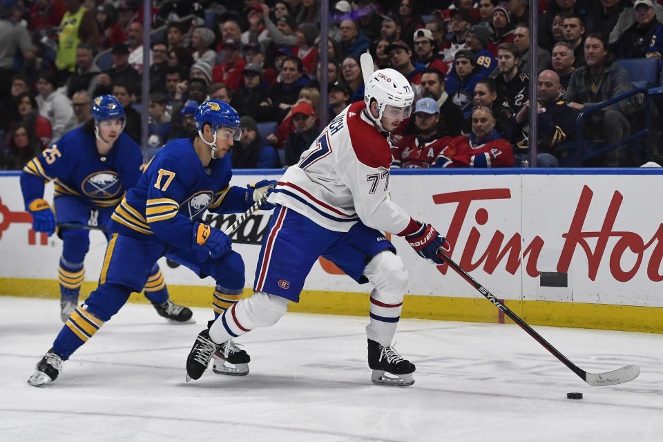 Montreal Canadiens center Kirby Dach, right, reaches for the puck in front of Buffalo Sabres center Tyson Jost during the first period of an NHL hockey game in Buffalo, N.Y., Monday, March 27, 2023. (AP Photo/Adrian Kraus)