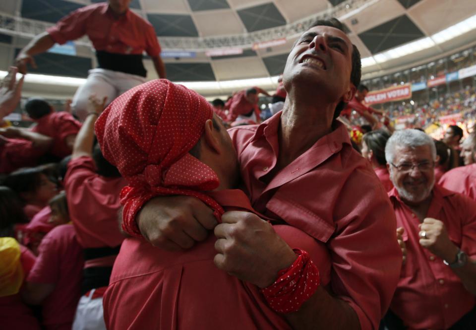 Members of Colla Vella Xiquets de Valls celebrate after forming a human tower called "castell" during a biannual competition in Tarragona October 5, 2014. The formation of human towers is a tradition in Catalonia. (REUTERS/Albert Gea)