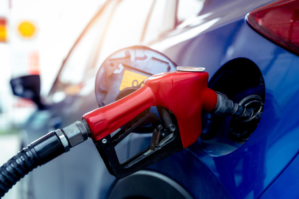 Car fueling at gas station. Refuel fill up with petrol gasoline. Petrol pump filling fuel nozzle in fuel tank of car at gas station. Petrol industry and service. Petrol price and oil crisis concept.