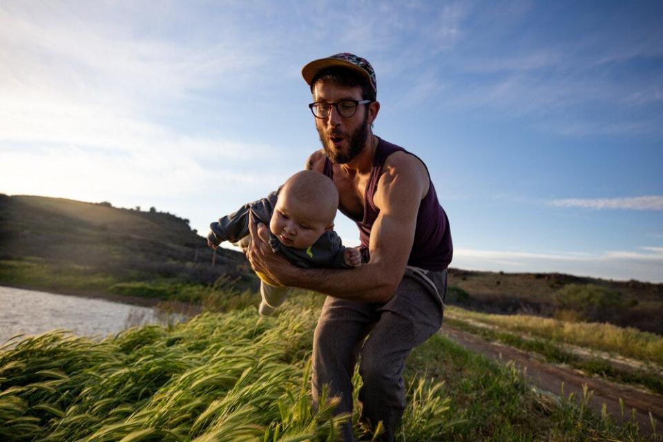 Rob Jameson flies his 4-month-old, Nova, over the grass in Arcosanti, Arizona on April 9, 2019. Jameson heard on a podcast that interacting with nature will help develop a baby’s sense of curiosity.