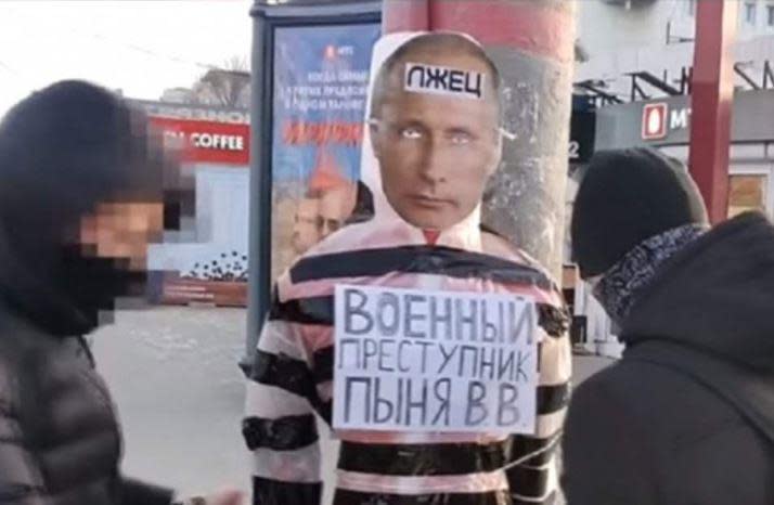 Russian activists stand near a mannequin dressed as President Vladimir Putin, with signs calling him a liar and war criminal, in the town of Perm in the Urals region, in an image from a YouTube video shared by Amnesty International.  / Credit: Amnesty International/YouTube