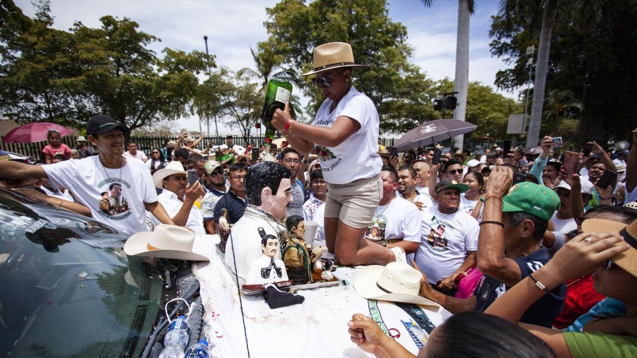 Gläubiger gießt Whisky über die Büste von Jesus Malverde, der in Mexiko als Heiliger der Drogenbosse gilt. Foto: Roberto Armenta