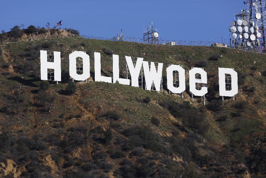 Los Angeles County firemen remove banners from the letters on the Hollywood sign, seen vandalized Sunday, Jan. 1, 2017. Los Angeles residents awoke New Year's Day to find a prankster had altered the famed Hollywood sign to read "HOLLYWeeD." Police have notified the city's Department of General Services, whose officers patrol Griffith Park and the area of the rugged Hollywood Hills near the sign. California voters in November approved Proposition 64, which legalized the recreational use of marijuana, beginning in 2018. (AP Photo/Damian Dovarganes)