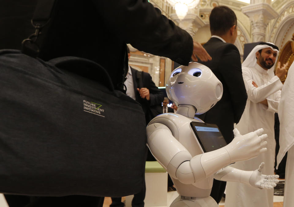 A robot welcomes a participant at the Future Investment Initiative forum during the opening session in Riyadh, Saudi Arabia, Tuesday, Oct. 29, 2019. The long-planned initial public offering of a sliver of Saudi Arabia’s state-run oil giant Saudi Aramco will see shares traded on Riyadh’s stock exchange in December, a Saudi-owned satellite news channel reported Tuesday as the kingdom’s marquee investment forum got underway. (AP Photo/Amr Nabil)