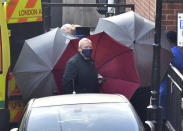 Staff use umbrellas to shield entrance to an ambulance outside the rear of the King Edward VII Hospital in London where Prince Philip is being treated Monday March 1, 2021. (Dominic Lipinski/PA via AP)