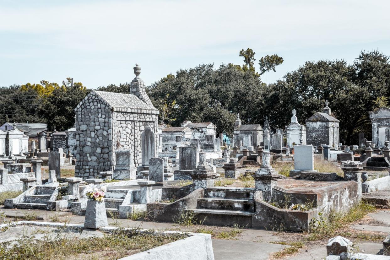 a sunny day in an old cemetery with ruined ornamental tombs lafayette cemetery no 2 in new orleans