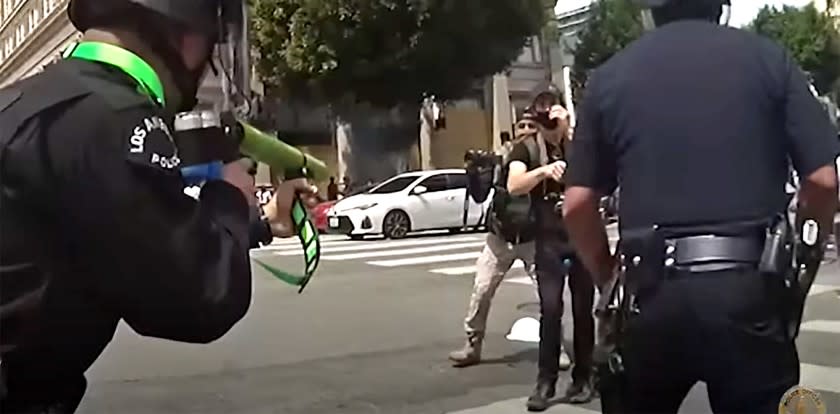Newly-released body-camera footage from protests in Los Angeles this summer shows Los Angeles police officers yank a large protest sign from the hands of a man in a Hollywood intersection, shove him backwards as he puts his hands up, then shoot him in the groin with a projectile at close range.