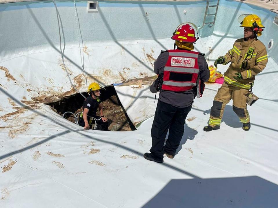 First responders work in a sinkhole in Israel.