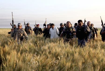 Iraqi security forces arrest suspected militants of the al Qaeda-linked Islamic State in Iraq and the Levant (ISIL) during a raid and weapons search operation in Hawija in this April 24, 2014 file photo. REUTERS/Yahya Ahmad/Files