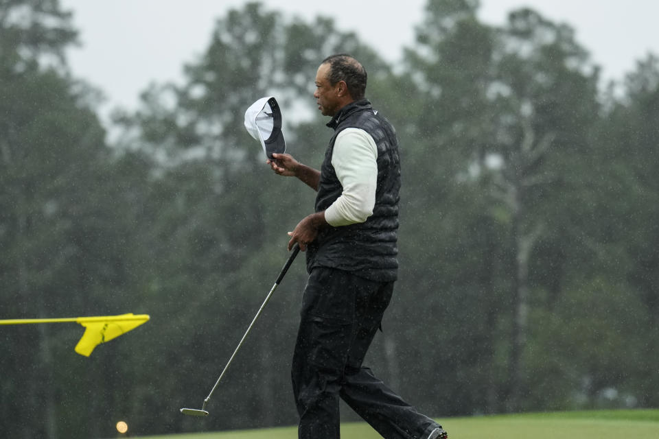 Tiger Woods walks off the on the 18th green after his weather delayed second round of the Masters golf tournament at Augusta National Golf Club on Saturday, April 8, 2023, in Augusta, Ga. (AP Photo/Charlie Riedel)