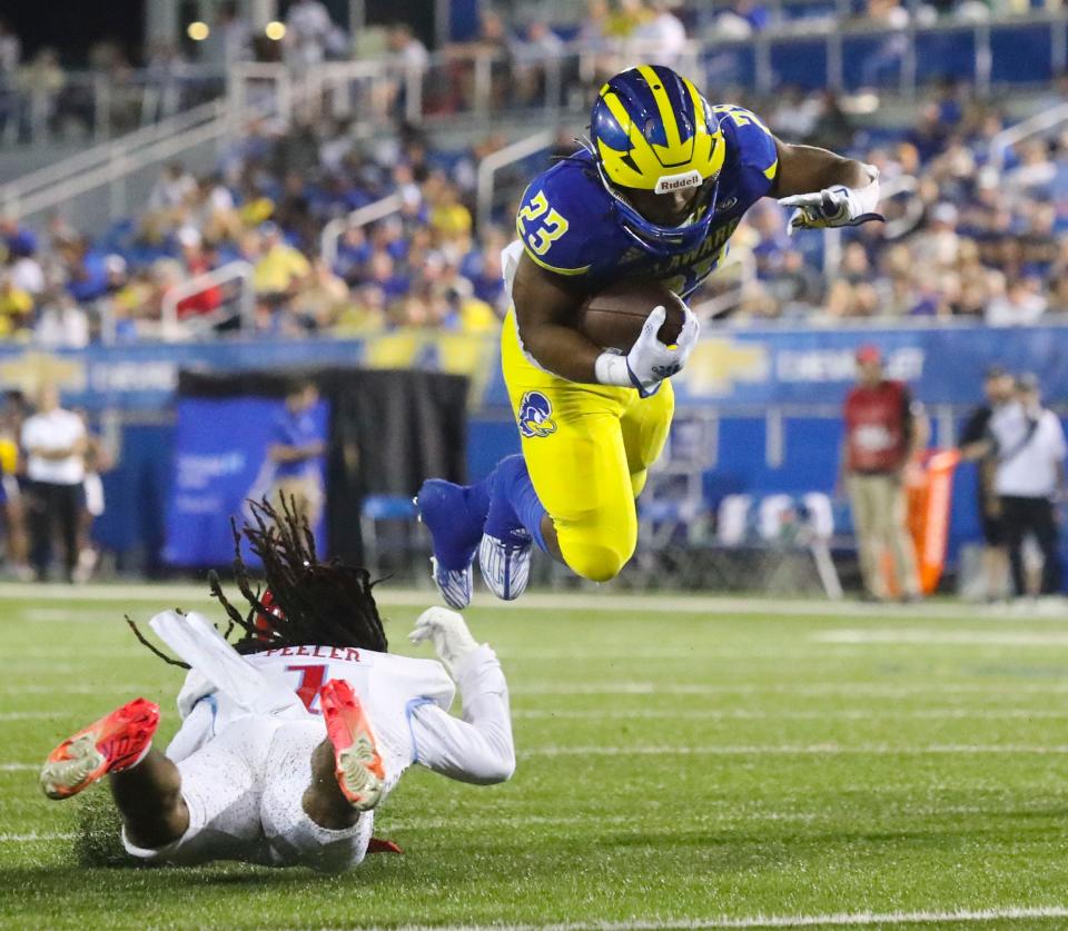 Delaware State's Charles Peeler trips up Delaware's Quincy Watson in the third quarter of the Blue Hens' 35-9 win at Delaware Stadium, Saturday, Sept. 10, 2022.