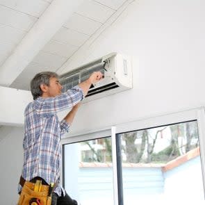 Repairman fixing air conditioner unit