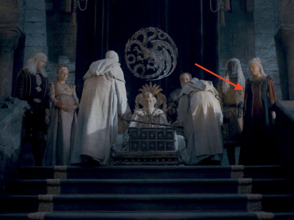 A group of royals on a raised platform in a castle.