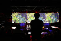 A man stands in the rows during the final of League of Legends tournament between Team G2 Esports and Team FunPlus Phoenix, in Paris, Sunday, Nov. 10, 2019. The biggest e-sports event of the year saw a Chinese team, FunPlus Phoenix, crowned as world champions of the video game League of Legends. Thousands of fans packed a Paris arena for the event, which marked another step forward for the growing esports business. (AP Photo/Thibault Camus)