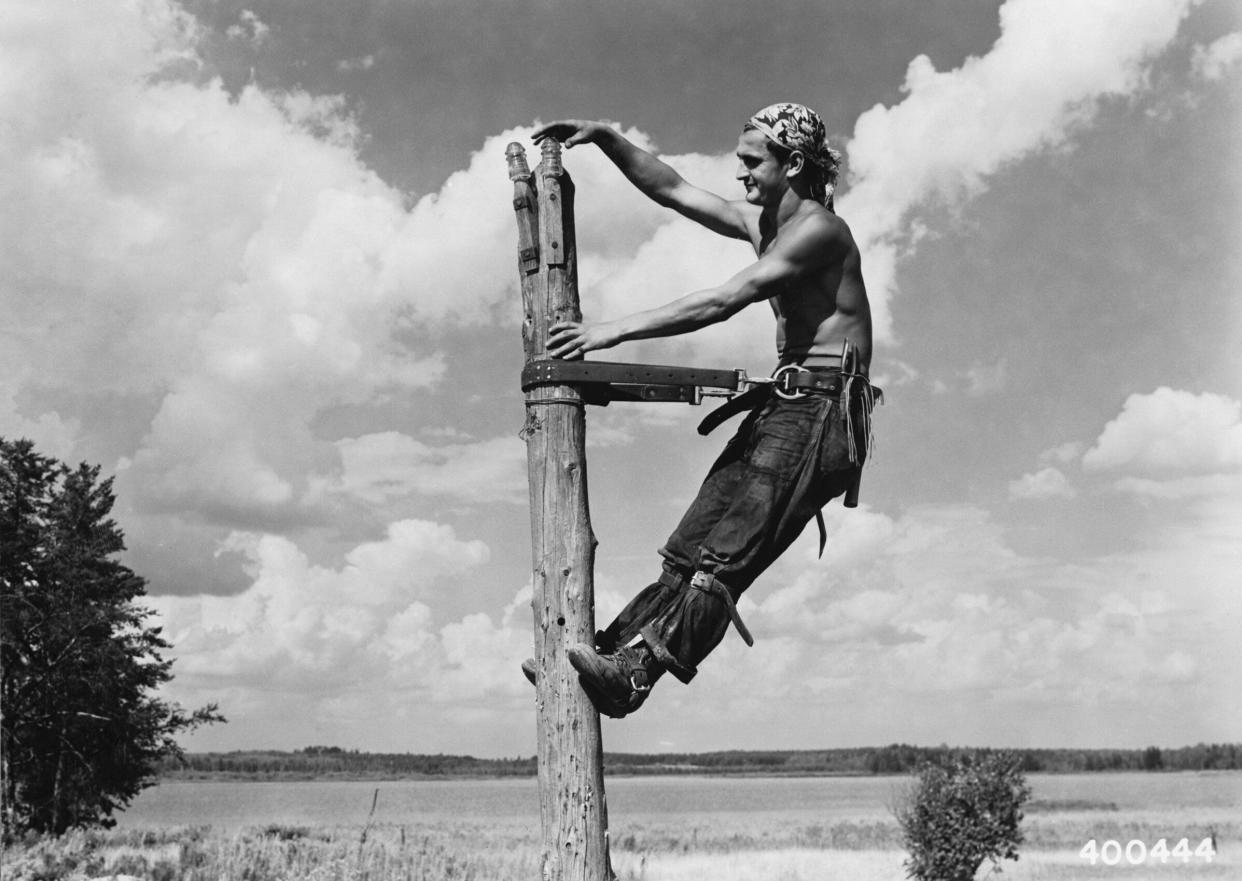 Civilian Conservation Corps worker Carl Simon installs insulators on top of a telephone pole about 1940 in Superior National Forest in Minnesota. (Photo: Corbis via Getty Images)