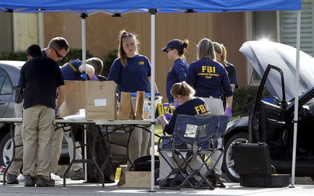 FBI agents gather evidence in front of the Redlands residence and vehicle belonging to the shooters in connection to the Wednesday massacre in San Bernardino, California December 3, 2015. REUTERS/Alex Gallardo