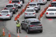 A National Guardsman directs traffic at a COVID-19 testing site outside Hard Rock Stadium, Wednesday, July 8, 2020, in Miami Gardens, Fla. Florida is one of the nation's hot spots for coronavirus. (AP Photo/Wilfredo Lee)