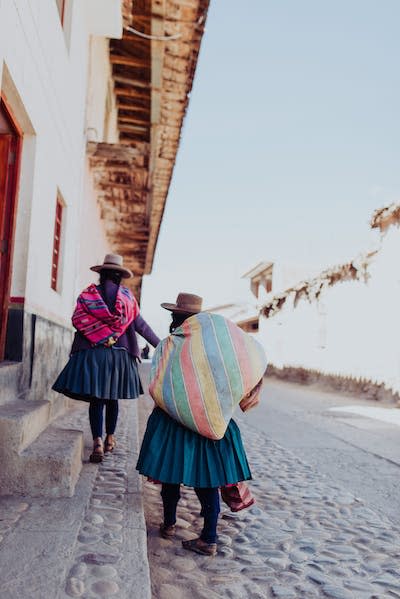 Fotografía de dos indígenas de espalda en una calle de la región de Cuzco. <a href="https://unsplash.com/es/fotos/hNPX9p95CGc" rel="nofollow noopener" target="_blank" data-ylk="slk:Persnickety Prints / Unsplash;elm:context_link;itc:0;sec:content-canvas" class="link ">Persnickety Prints / Unsplash</a>