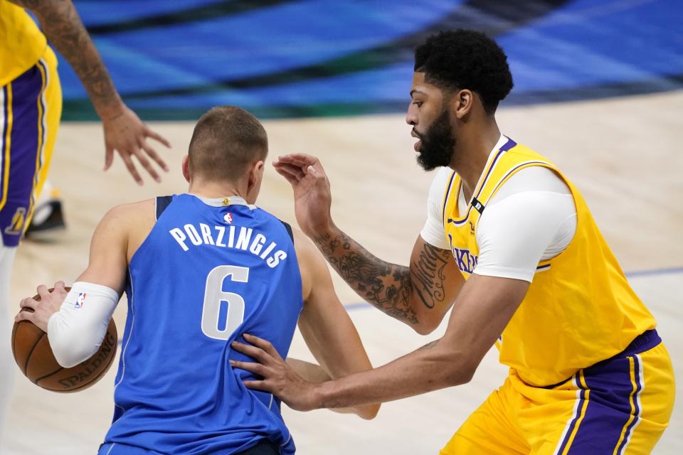 Dallas Mavericks' Kristaps Porzingis (6) works to the basket against Los Angeles Lakers forward Anthony Davis during the first half of an NBA basketball game in Dallas, Thursday, April 22, 2021. (AP Photo/Tony Gutierrez)