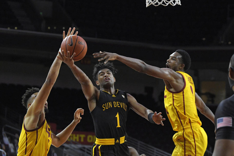 Arizona State guard Remy Martin, center, shoots as Southern California forwards Isaiah Mobley, left, and Evan Mobley defend during the second half of an NCAA college basketball game Wednesday, Feb. 17, 2021, in Los Angeles. (AP Photo/Mark J. Terrill)