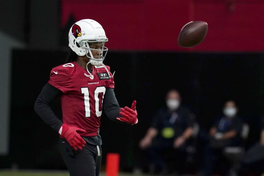 Arizona Cardinals' DeAndre Hopkins flips the football away after making a catch as wide receivers run drills during an NFL football workout Wednesday, Aug. 12, 2020, in Glendale, Ariz. (AP Photo/Ross D. Franklin)