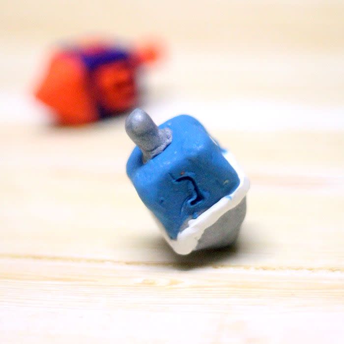 <p>There is no more classic Hanukkah game than dreidel. Spin the top and take or give up a share of the pot (usually pennies or chocolate coins) depending on where it lands. Give it an extra personal touch with homemade dreidels you can make out of clay. </p><p><em><a href="https://www.momsandcrafters.com/how-to-make-a-dreidel-out-of-clay/" rel="nofollow noopener" target="_blank" data-ylk="slk:Get the tutorial at Moms and Crafters »;elm:context_link;itc:0;sec:content-canvas" class="link ">Get the tutorial at Moms and Crafters »</a></em><br></p><p><strong>RELATED:</strong> <a href="https://www.goodhousekeeping.com/holidays/g34150986/hanukkah-crafts/" rel="nofollow noopener" target="_blank" data-ylk="slk:13 Festive Hanukkah Crafts for All Ages;elm:context_link;itc:0;sec:content-canvas" class="link ">13 Festive Hanukkah Crafts for All Ages</a></p>